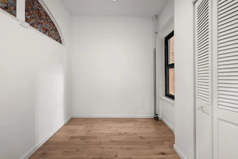 a view of a small space with wooden floor and a window