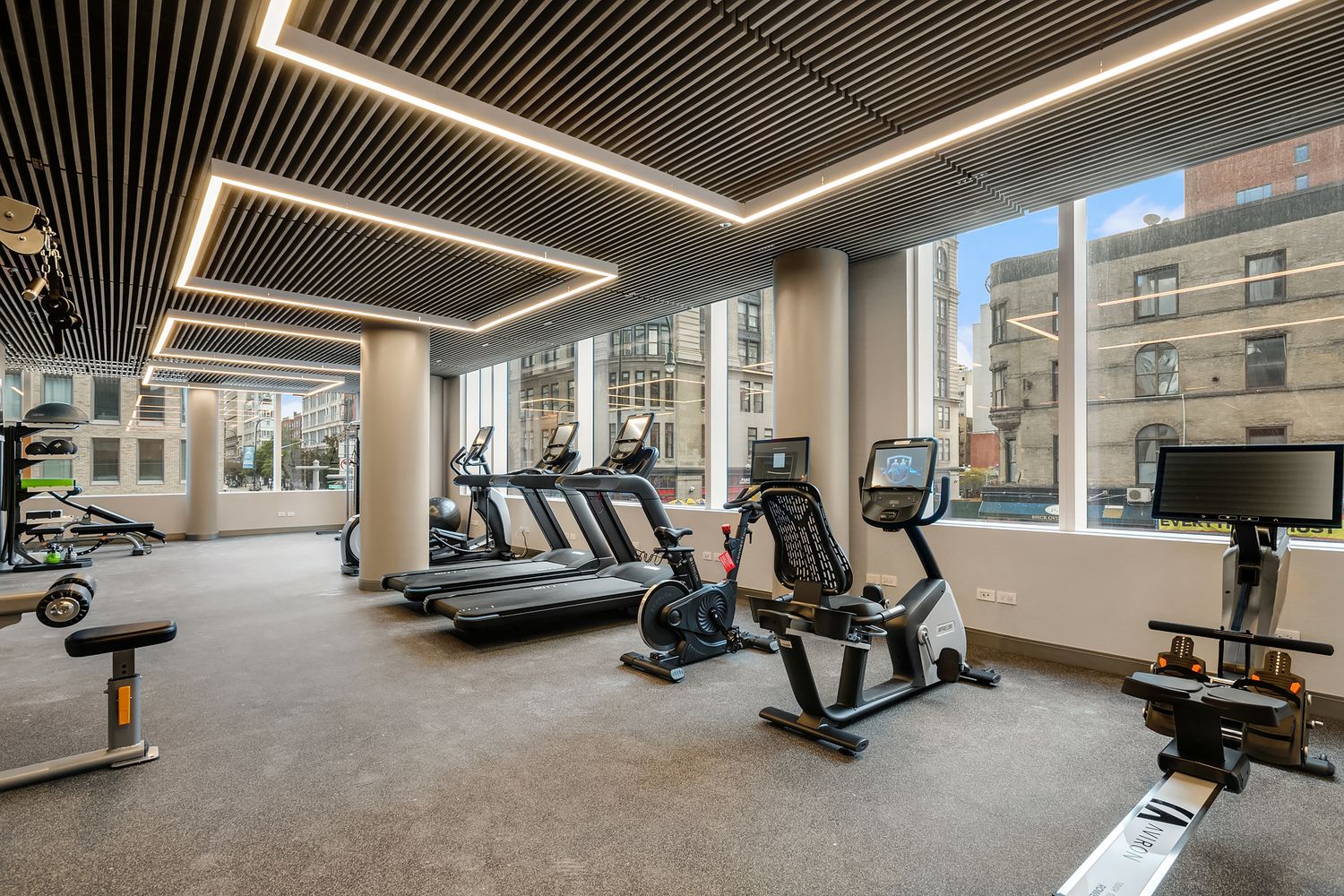a view of a livingroom with gym equipment and a large window