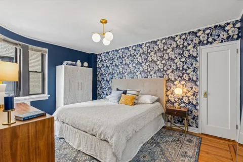 a bedroom with bed and wooden floor