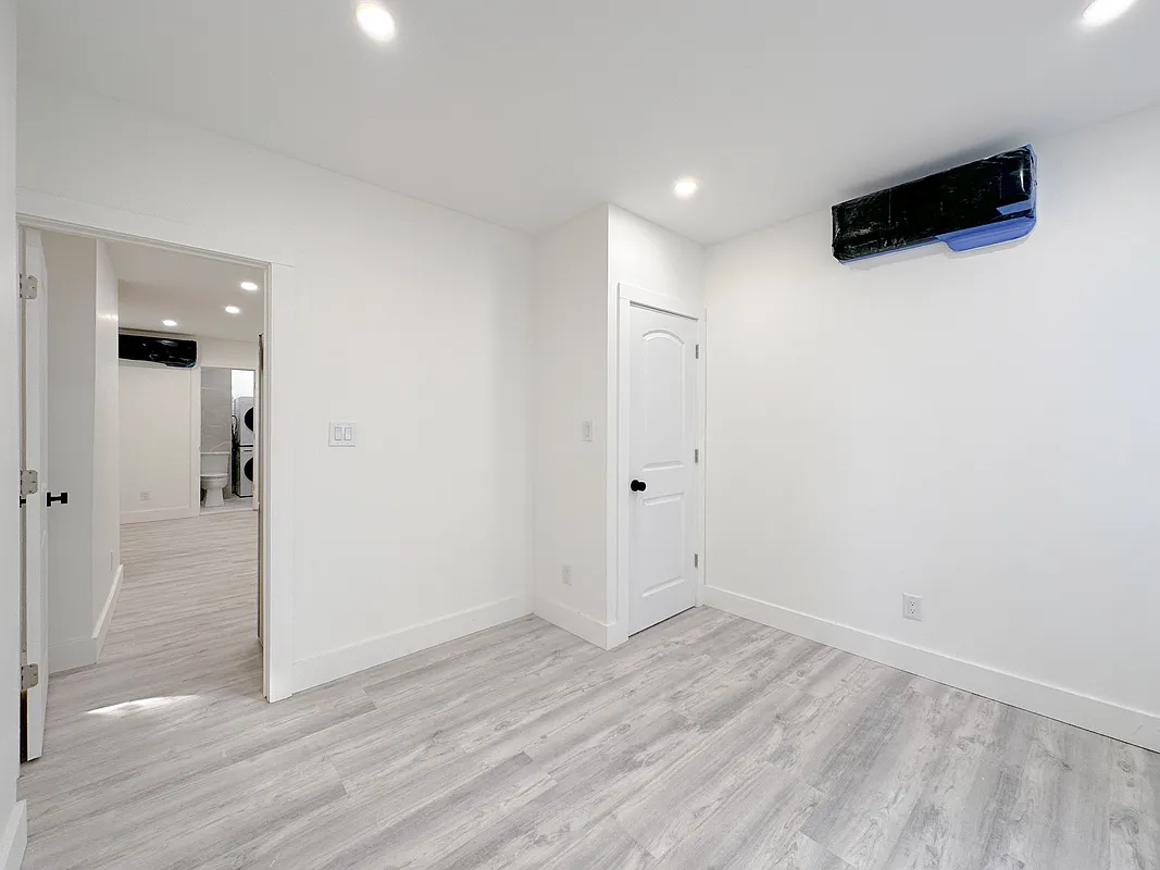 55 Spring Street, Unit 7 Manhattan, NY 10012 - Photo 4 of 12 an empty room with wooden floor and windows