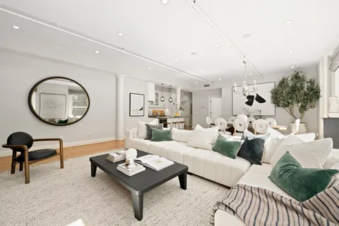 a living room with furniture a mirror and a large window