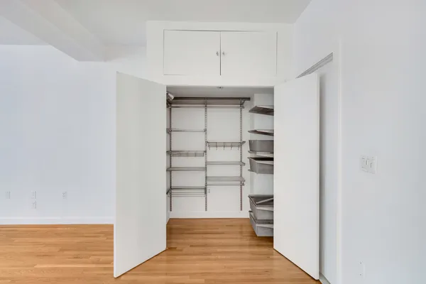 a view of walk in closet with empty racks