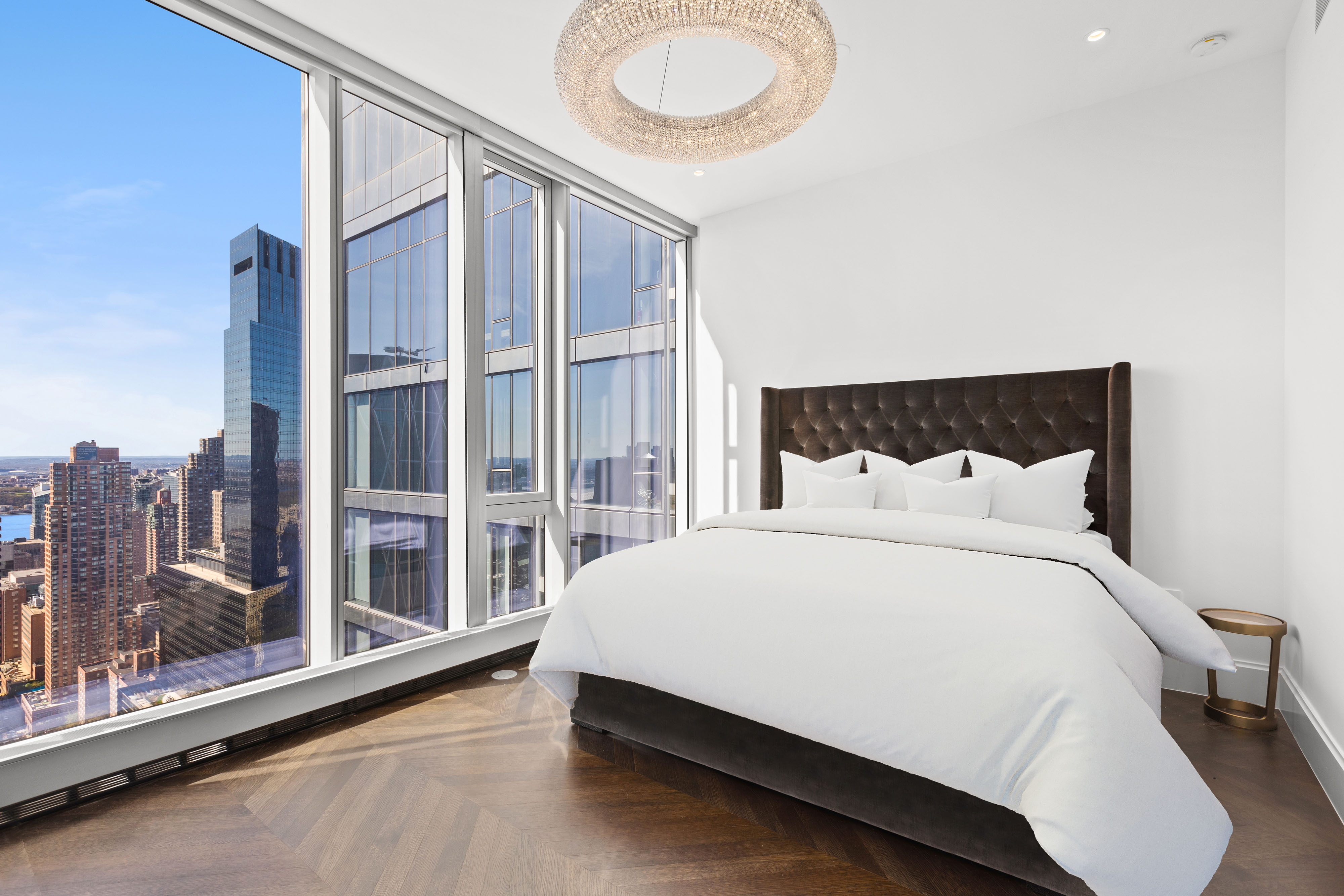 217 West 57th Street, Unit 48D Manhattan, NY 10019 - Photo 4 of 17 a large bed sitting in a bedroom next to a window