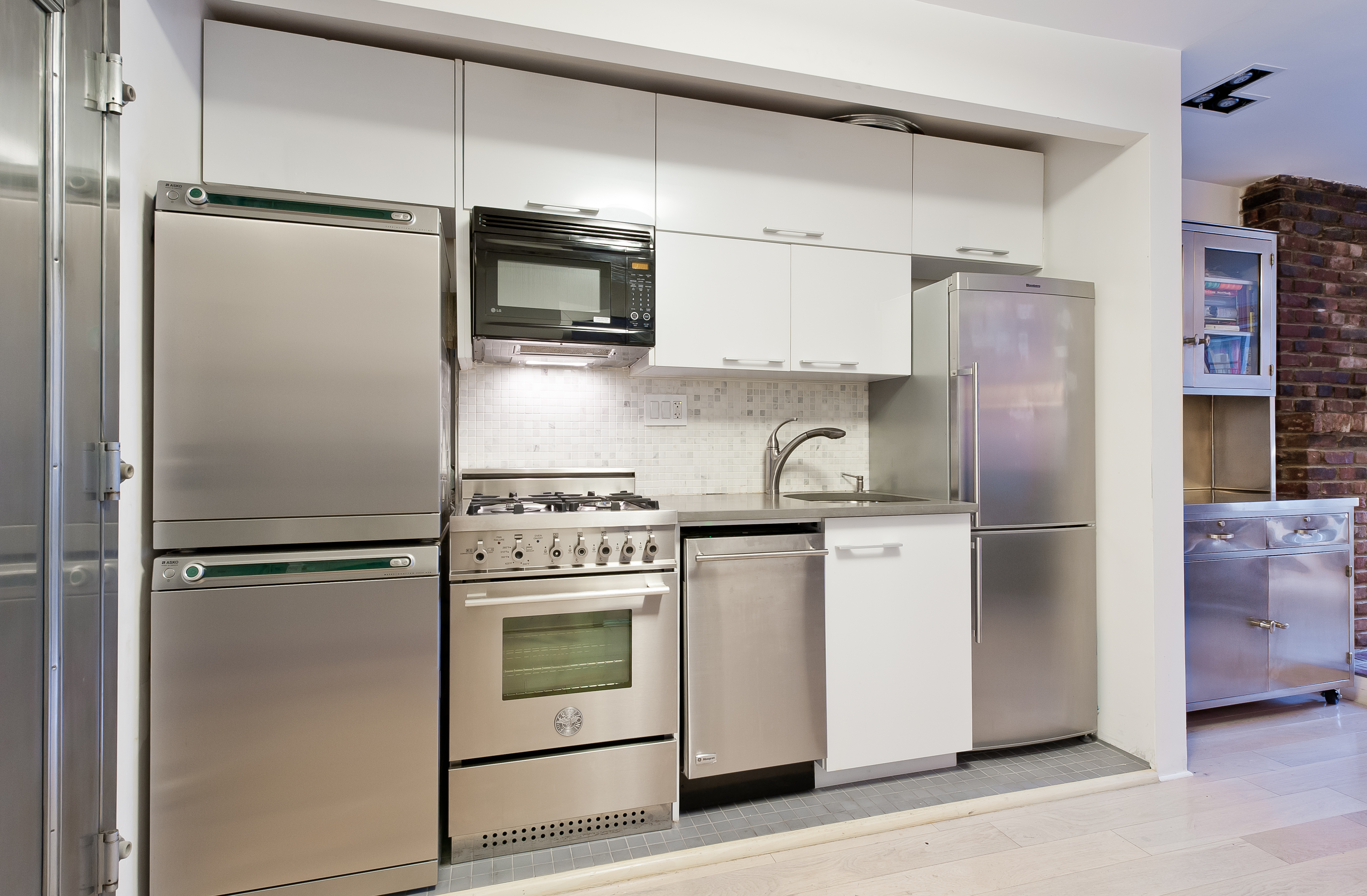 10 Charles Street, Unit 2B Manhattan, NY 10014 - Photo 6 of 8 a kitchen with stainless steel appliances a refrigerator stove and microwave