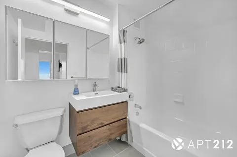 a bathroom with a sink toilet vanity and bathtub