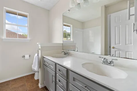 a bathroom with a granite countertop sink and a mirror