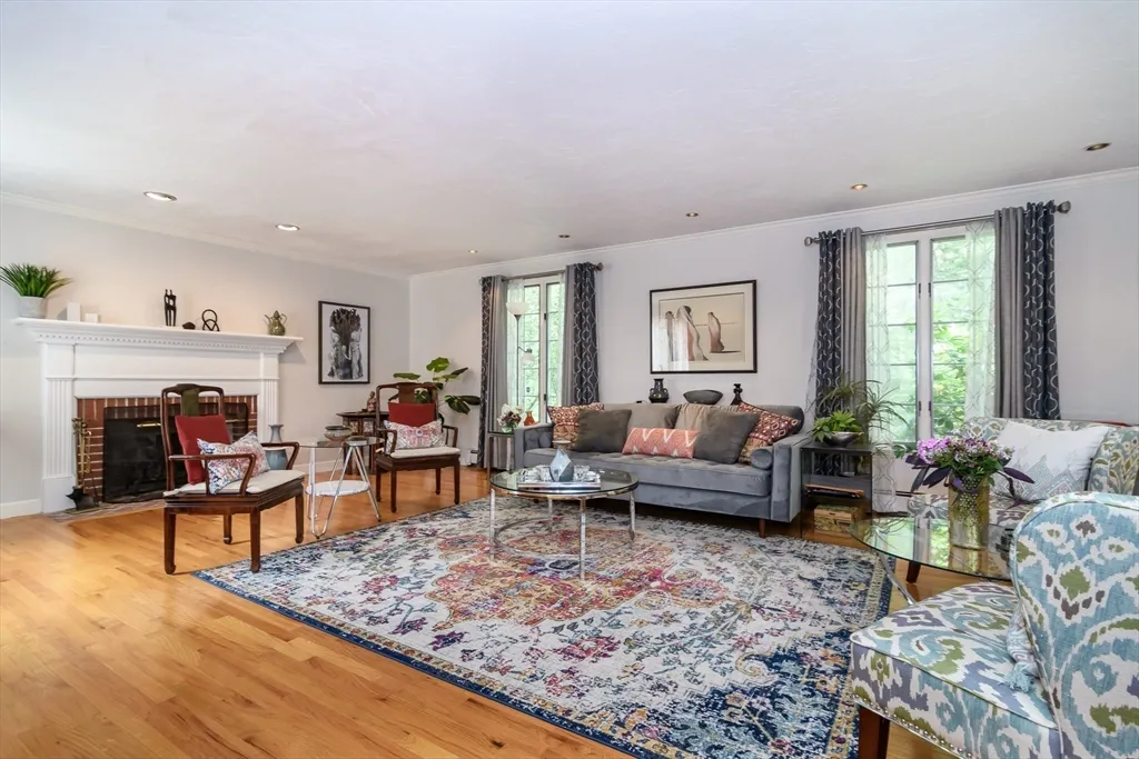 a living room with furniture large window and wooden floor