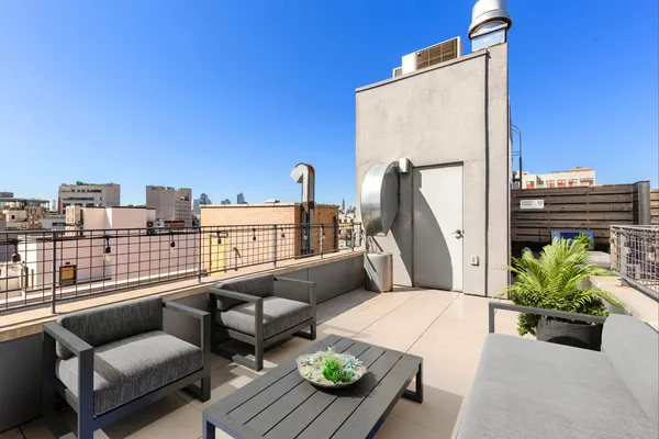 a balcony with furniture and a potted plant