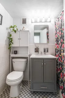 a bathroom with a sink vanity mirror and toilet