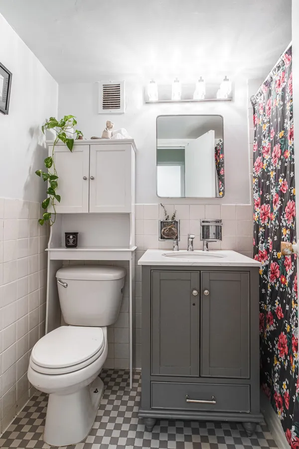 a bathroom with a sink vanity mirror and toilet