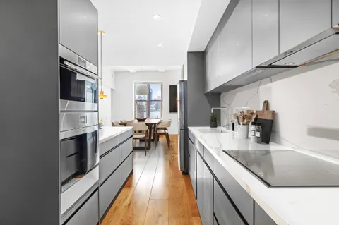 a kitchen with stainless steel appliances granite countertop sink stove top oven and cabinets