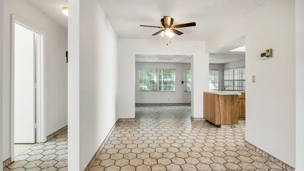a view of a hallway with a chandelier fan and windows