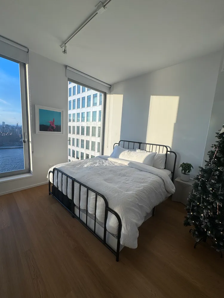 a bed sitting in a bedroom next to a window