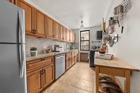 a kitchen with stainless steel appliances granite countertop a refrigerator sink and stove