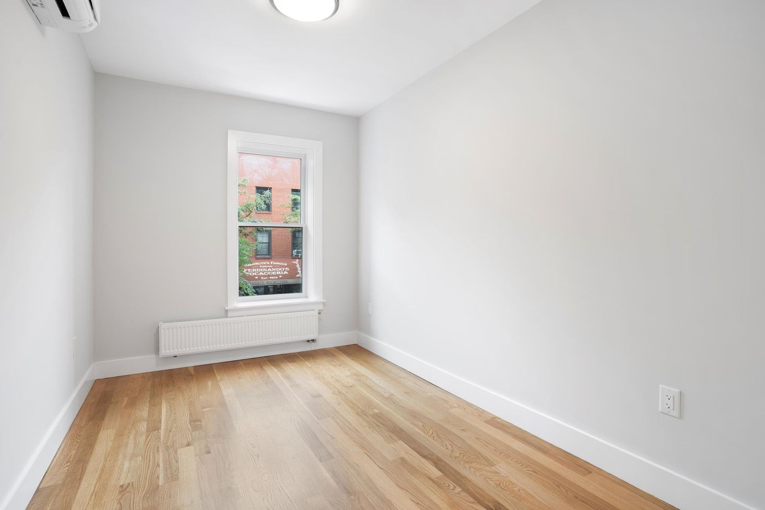 136 Union Street, Unit 2 Brooklyn, NY 11231 - Photo 8 of 9 a view of an empty room with wooden floor and a window