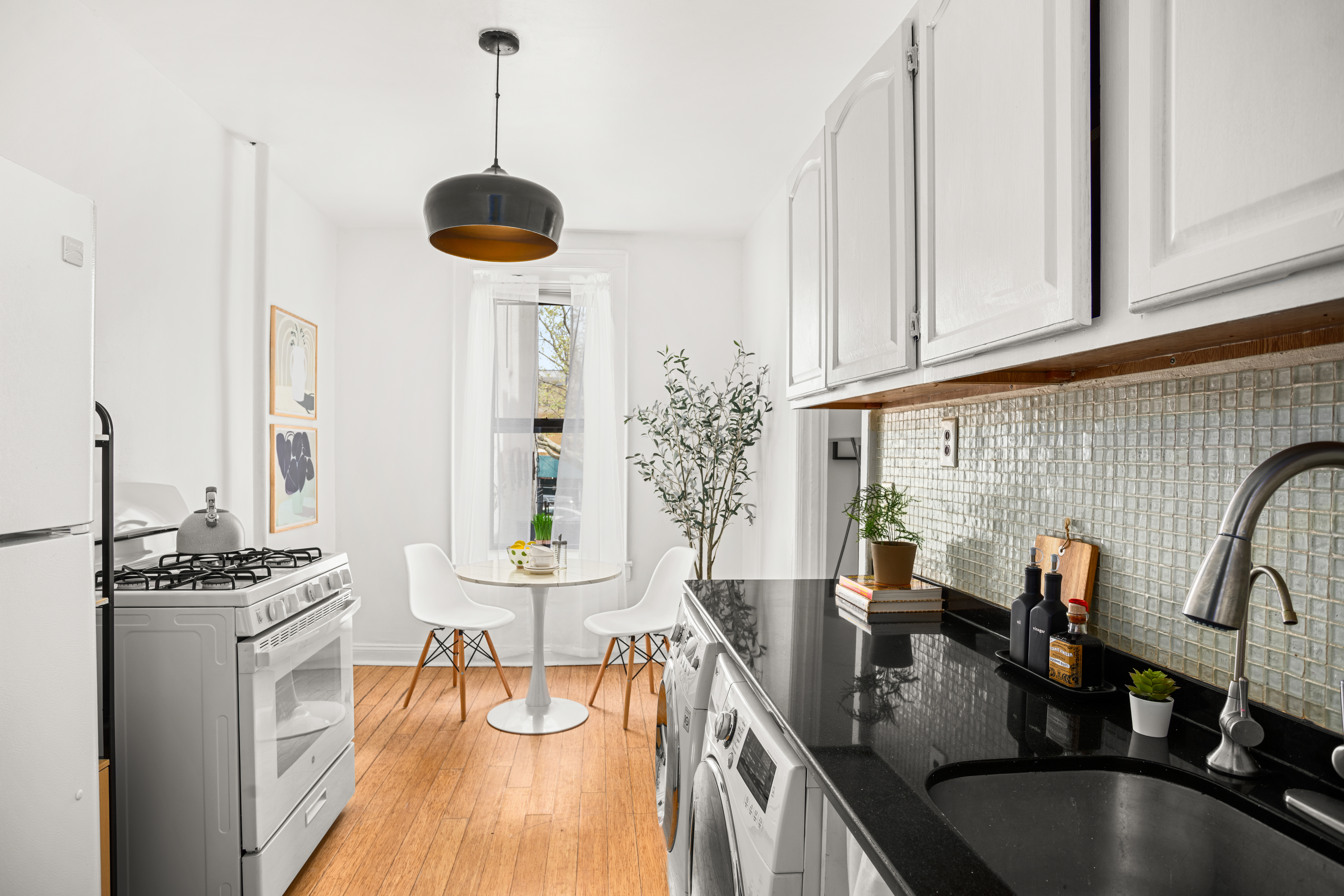465 Eastern Parkway, Unit C Brooklyn, NY 11216 - Photo 2 of 12 a kitchen with stainless steel appliances granite countertop a stove a sink dishwasher and white cabinets with wooden floor