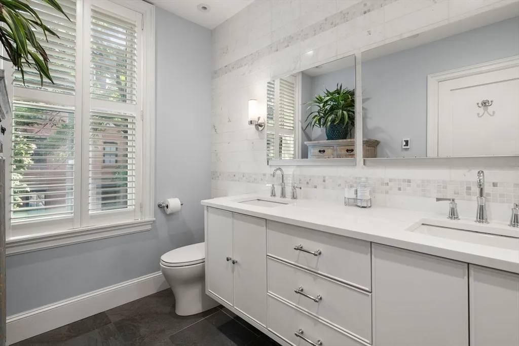 a bathroom with a granite countertop sink mirror and a toilet
