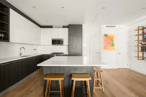 a kitchen with a table chairs sink and cabinets