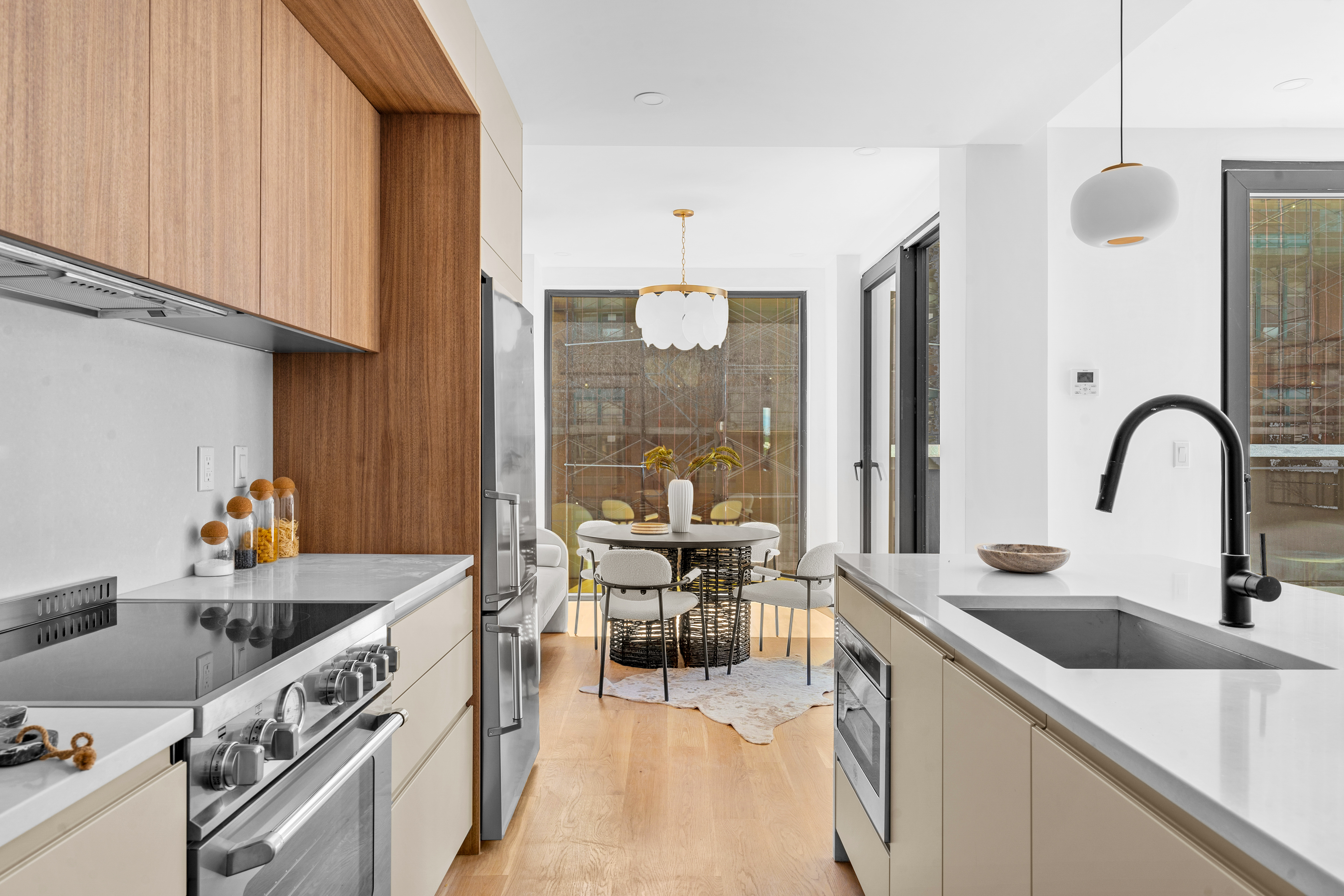 14-35 Broadway, Unit PH Queens, NY 11106 - Photo 6 of 24 a kitchen with granite countertop a sink and white cabinets