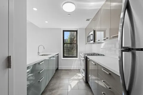 a kitchen with granite countertop a sink stove and refrigerator