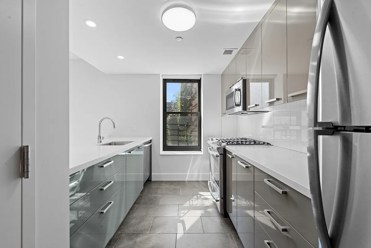 a kitchen with granite countertop a sink stove and refrigerator