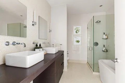 a bathroom with a double vanity sink a mirror a bathtub and shower