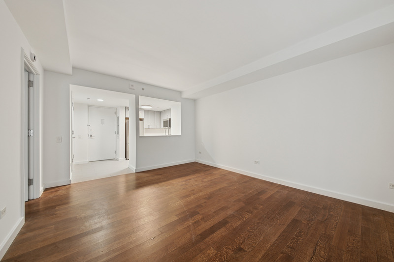 100 West 58th Street, Unit 5E Manhattan, NY 10019 - Photo 3 of 12 a view of an empty room with wooden floor and a window