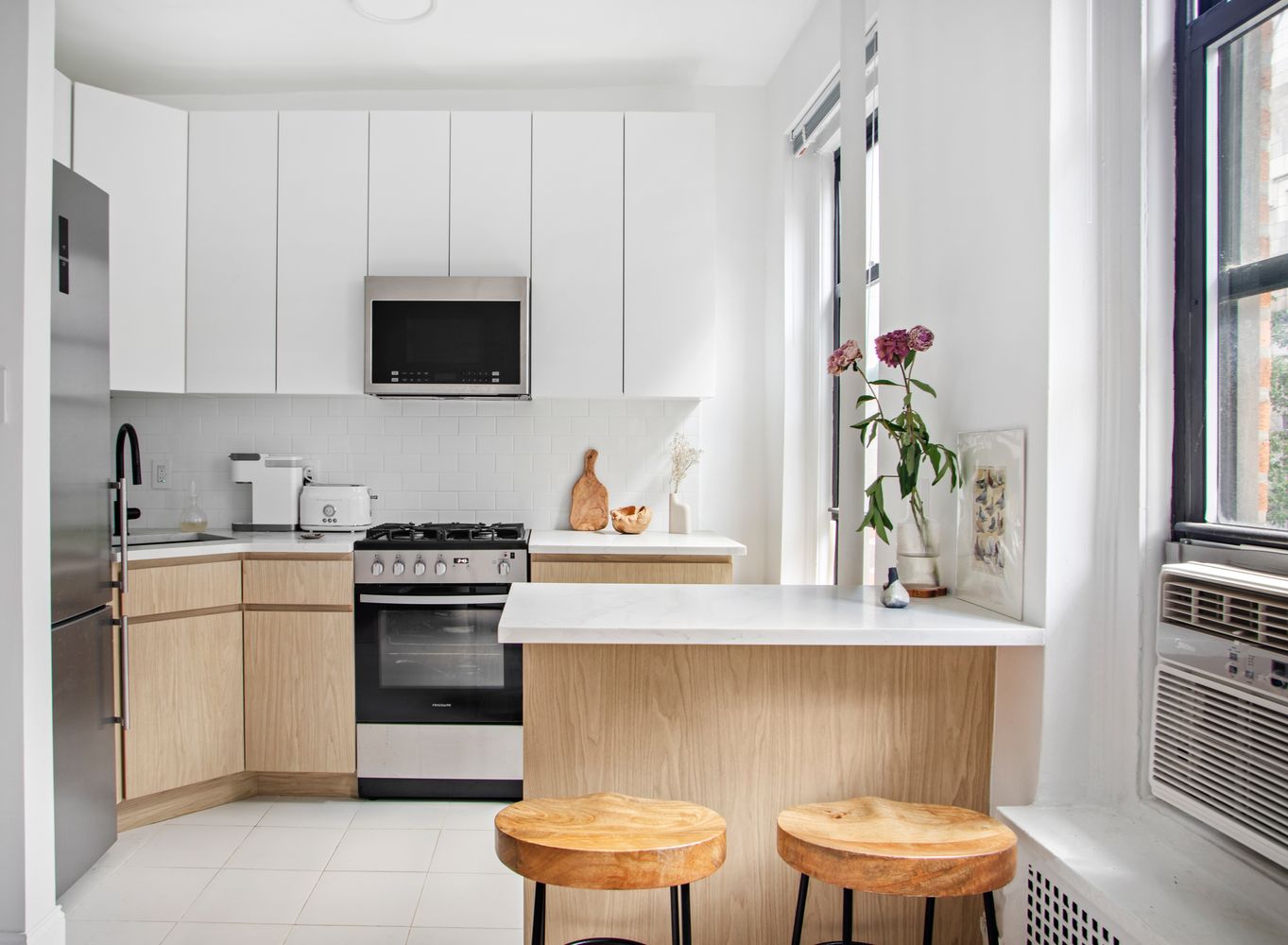 129 West 89th Street, Unit 45 Manhattan, NY 10024 - Photo 5 of 6 a kitchen with stainless steel appliances a white table and chairs in it