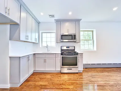 a kitchen with stainless steel appliances a stove a sink and a microwave
