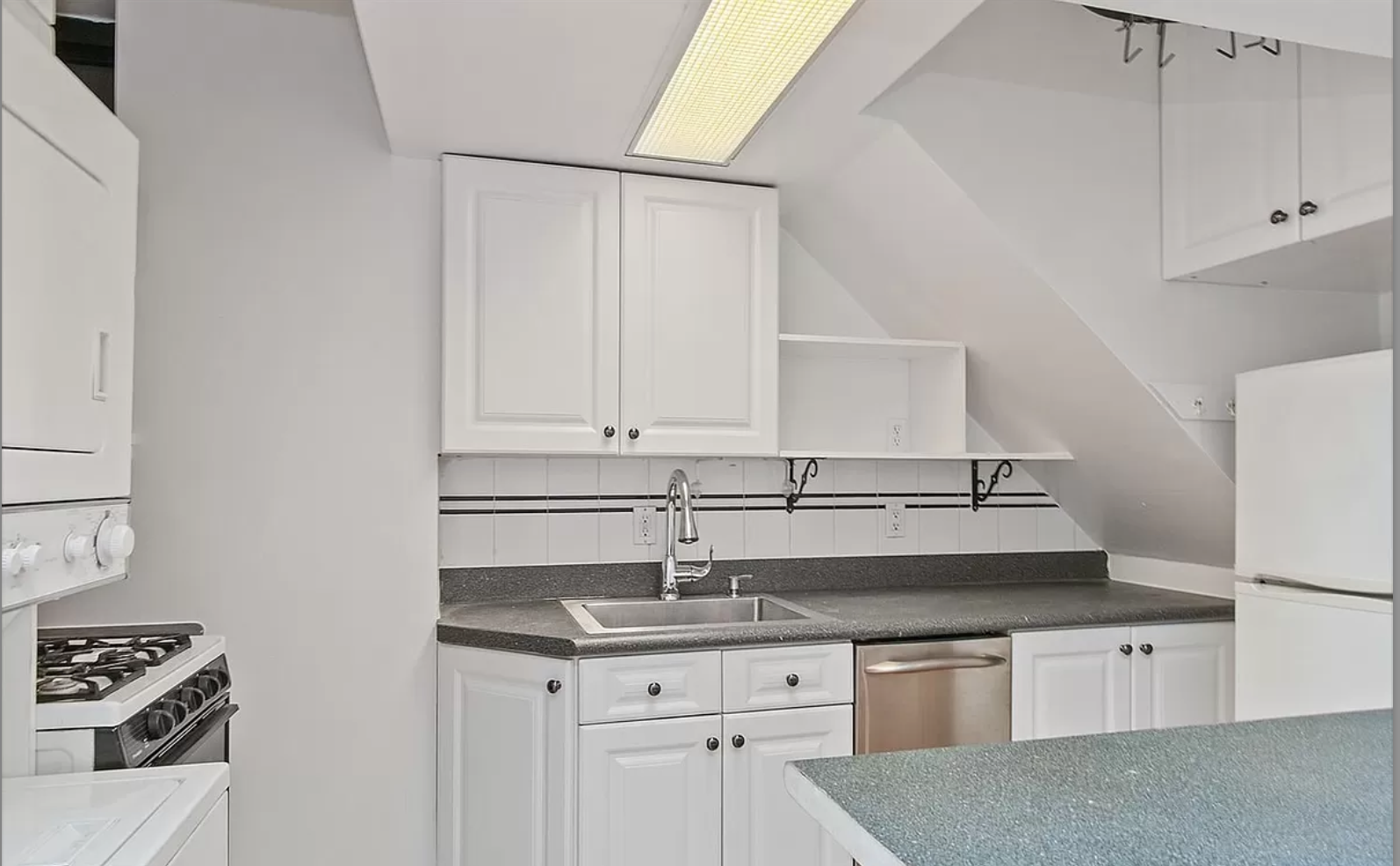 218 3rd Avenue, Unit 2 Manhattan, NY 10003 - Photo 4 of 9 a kitchen with granite countertop a sink and a stove