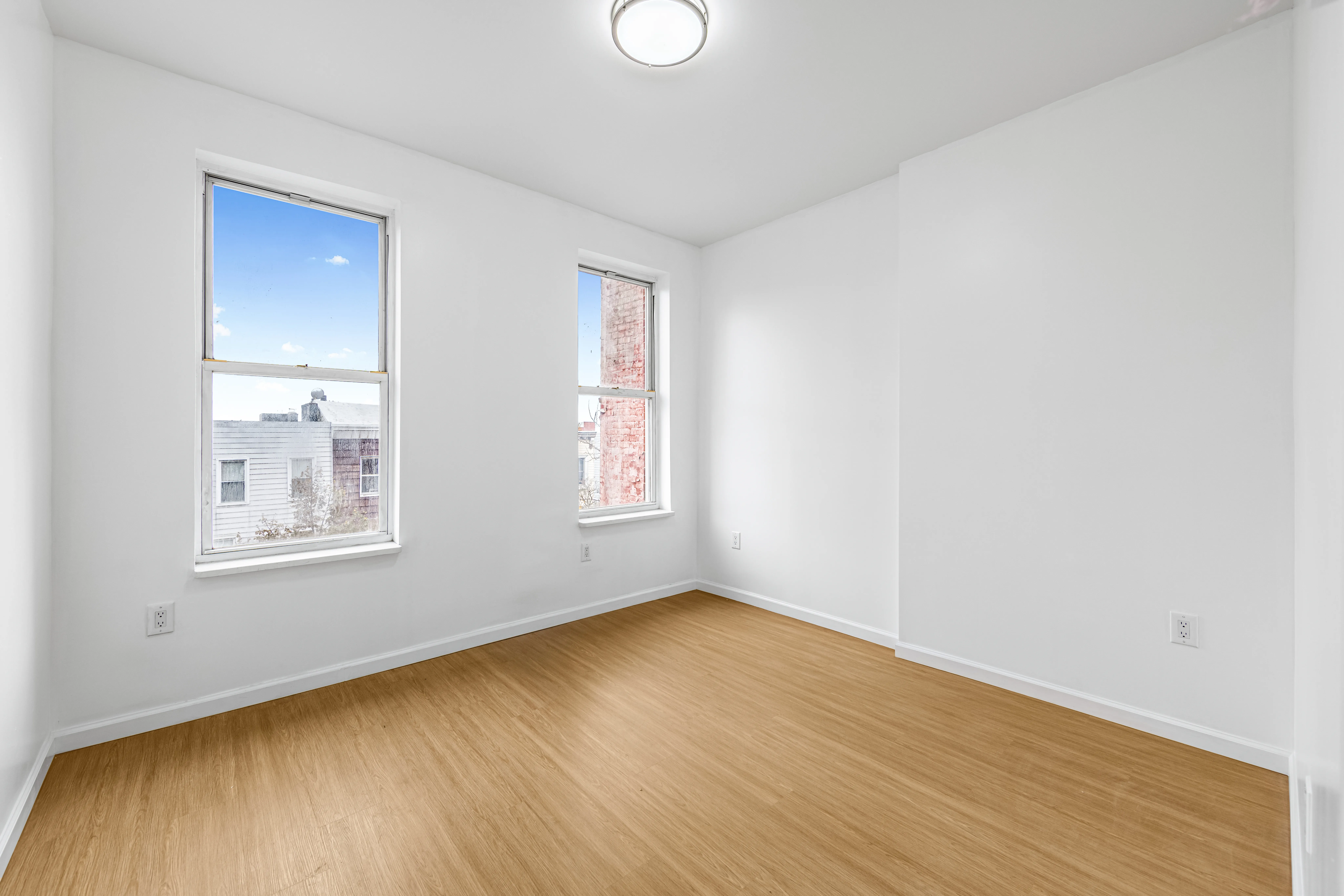 141 23rd Street, Unit 3L Brooklyn, NY 11232 - Photo 7 of 9 a view of an empty room with wooden floor and a window