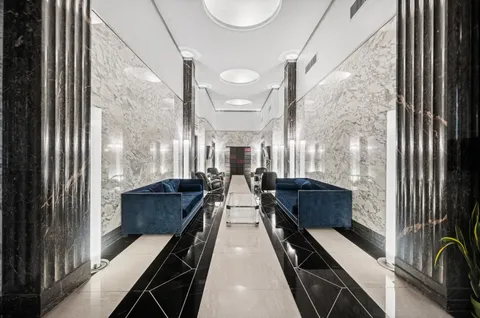 a lobby with furniture and a chandelier
