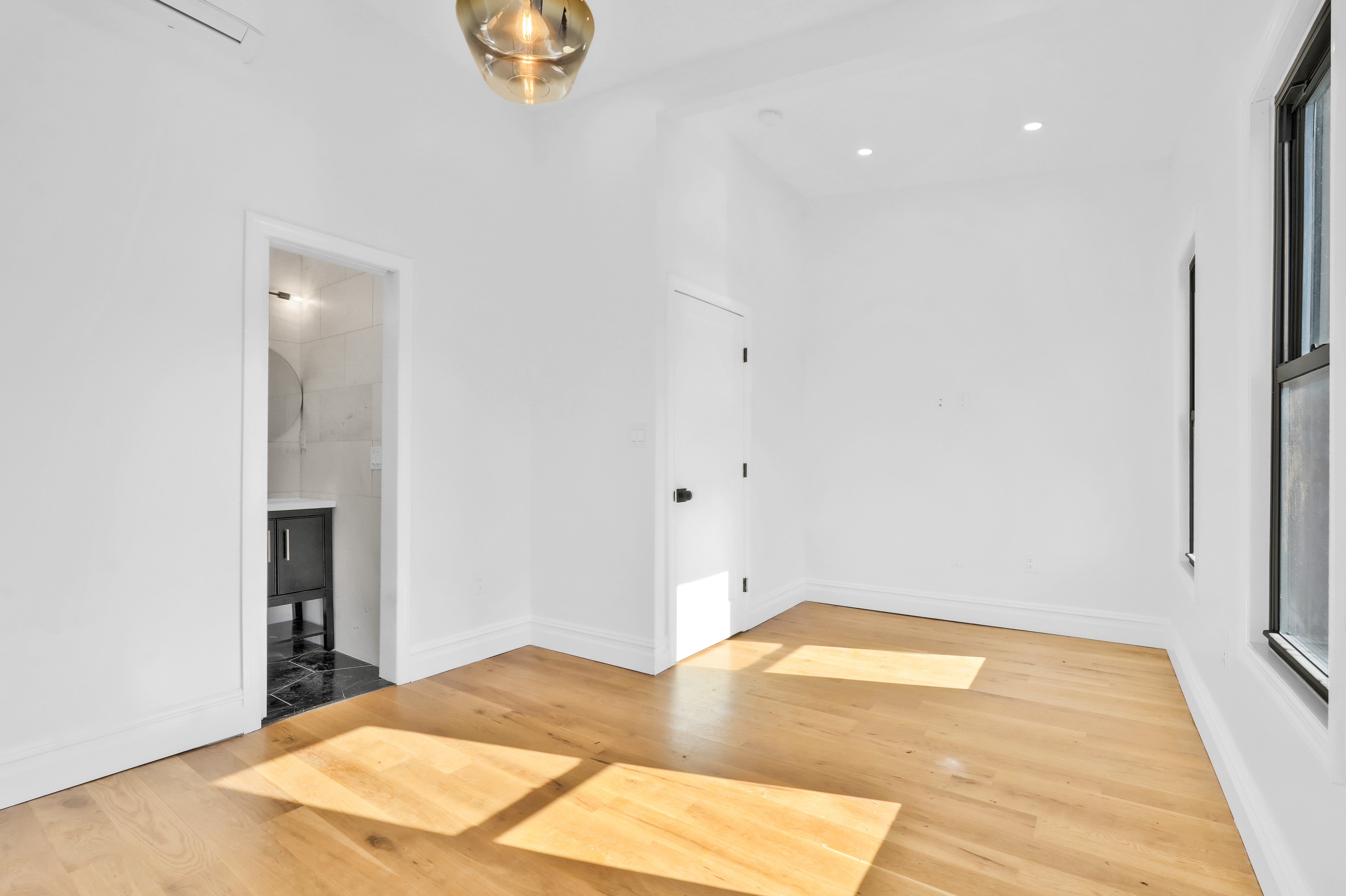 473 Monroe Street Brooklyn, NY 11221 - Photo 29 of 40 a bedroom with a bed and a chandelier