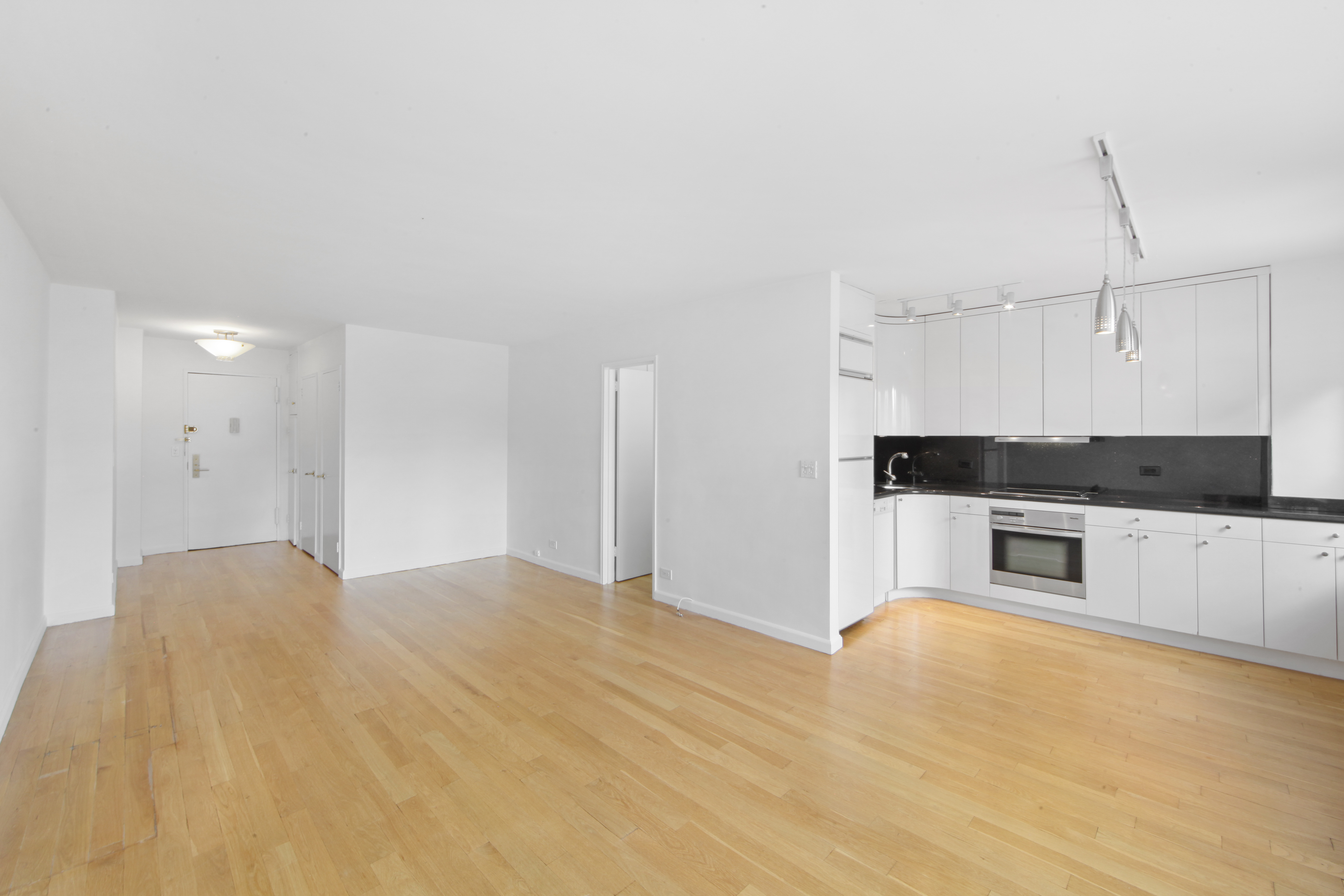 404 East 66th Street, Unit 11B Manhattan, NY 10065 - Photo 4 of 9 a kitchen with granite countertop a stove and a refrigerator