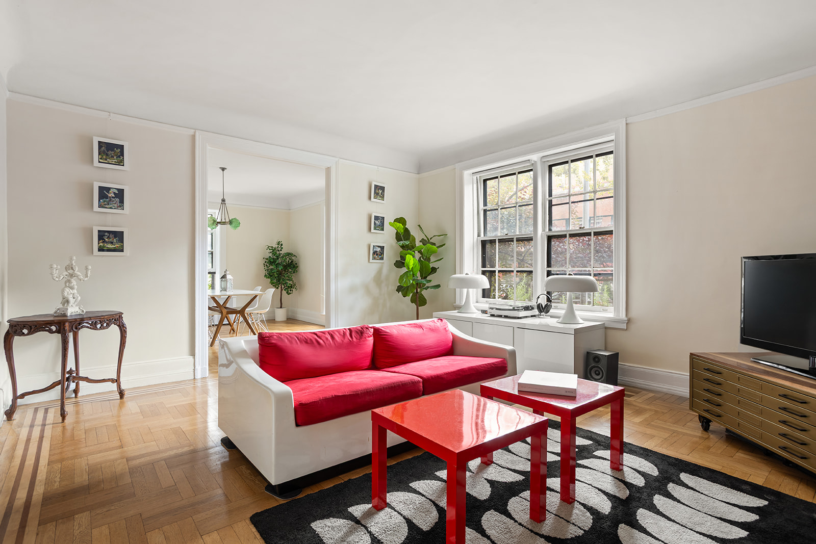 a living room with furniture a flat screen tv and a window