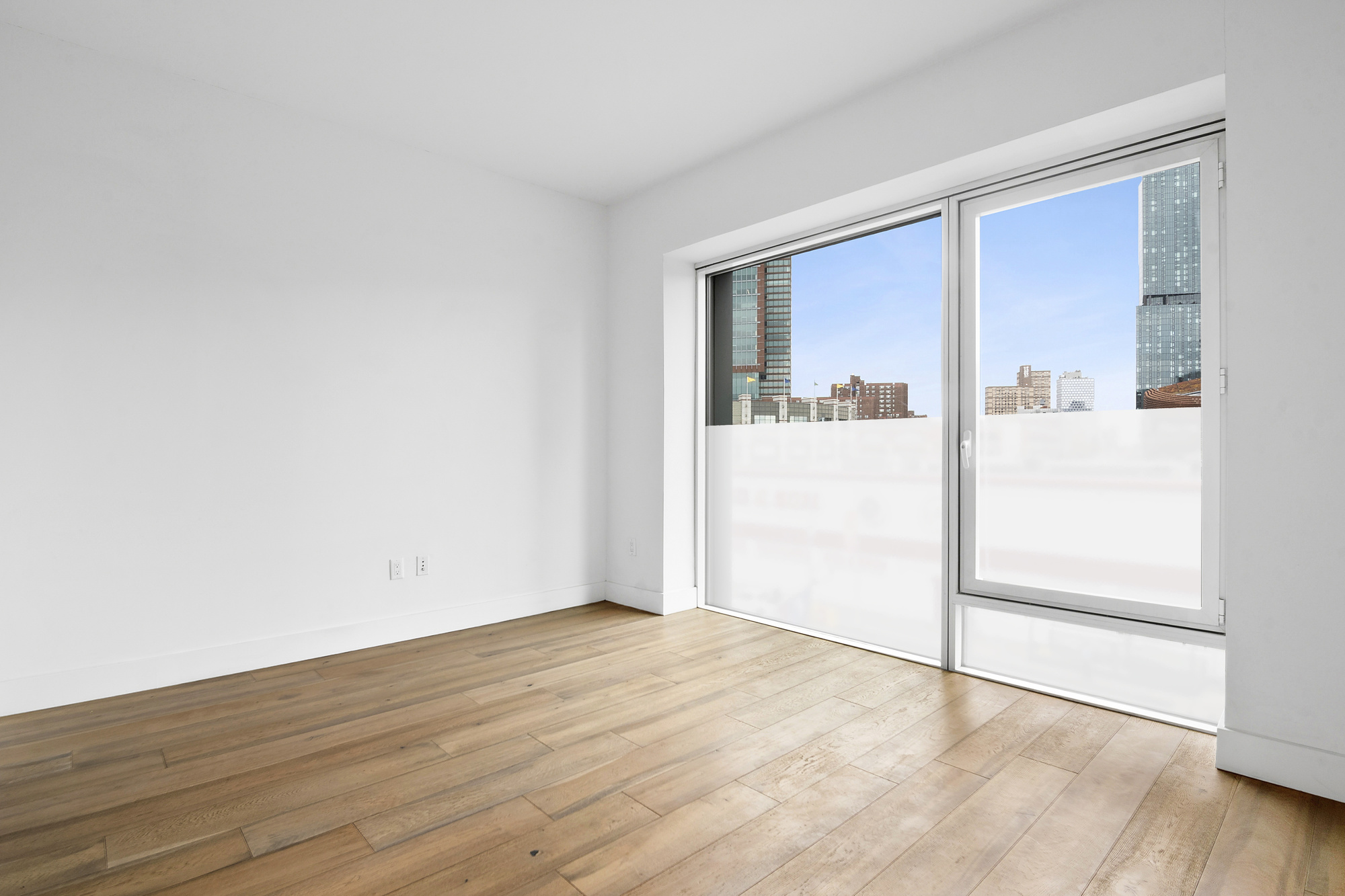 561 Pacific Street, Unit 404 Brooklyn, NY 11217 - Photo 7 of 10 an empty room with wooden floor and mirror