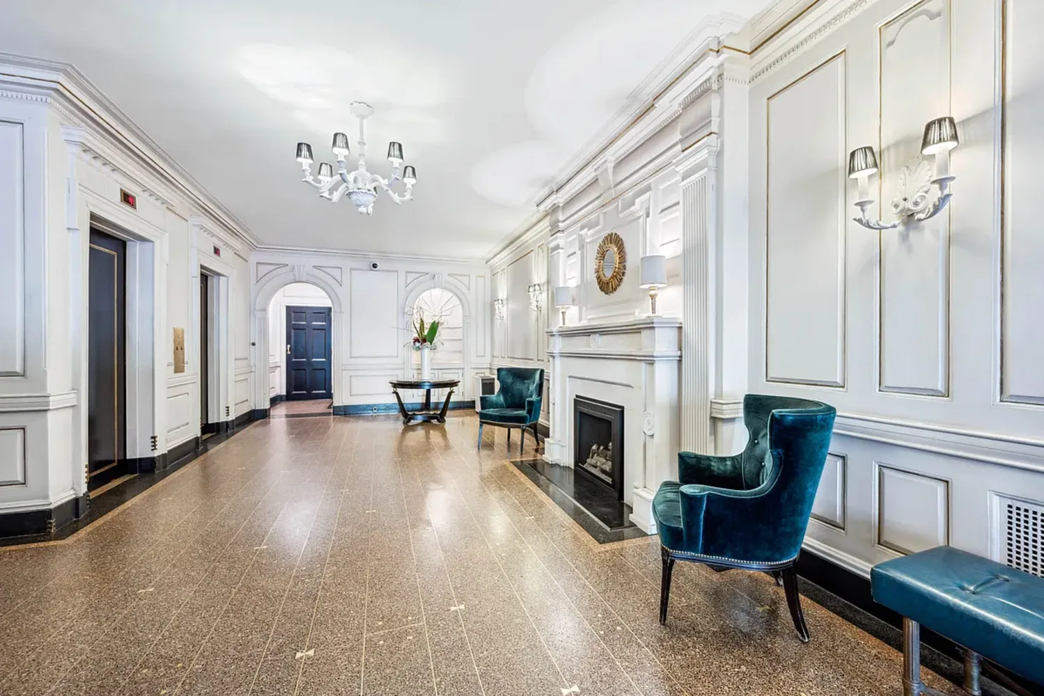a living room with furniture a fireplace and a chandelier
