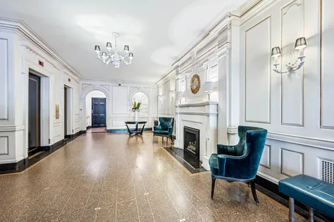a living room with furniture a fireplace and a chandelier