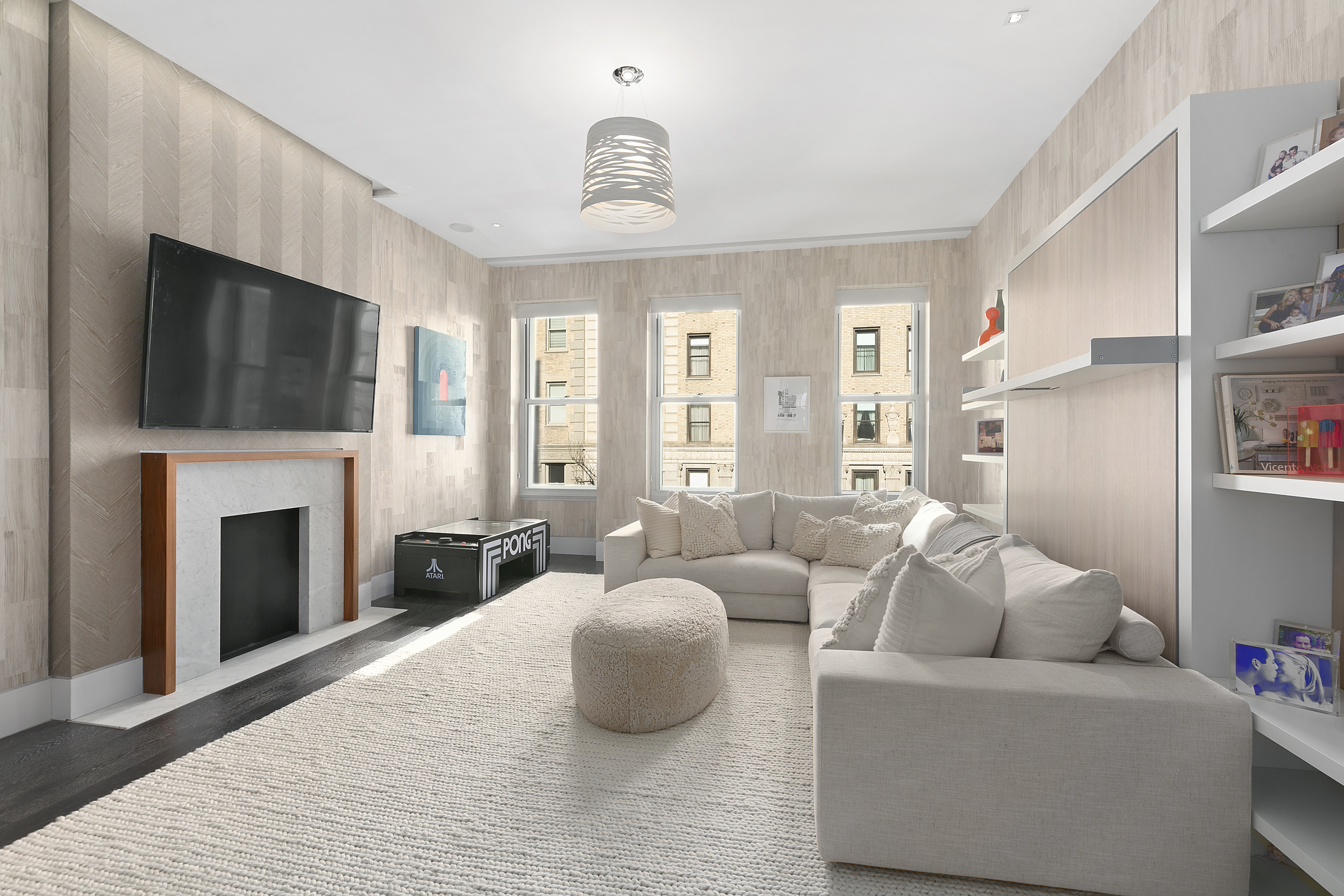 36 East 64th Street Manhattan, NY 10065 - Photo 16 of 27 a living room with furniture a fireplace and a flat screen tv