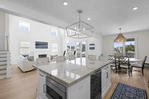 a view of a dining room and livingroom with furniture wooden floor a chandelier
