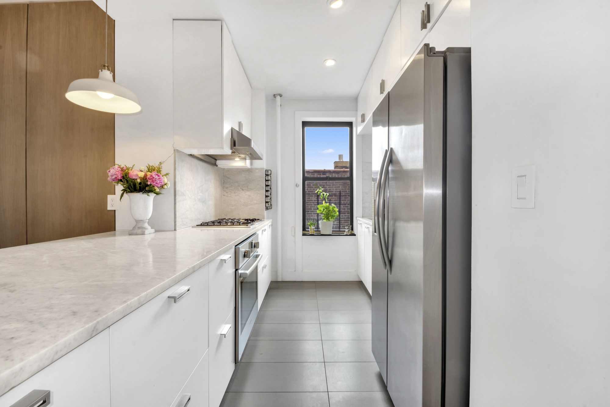 47 Fort Washington Avenue, Unit 61 Manhattan, NY 10032 - Photo 7 of 14 a kitchen with a sink and refrigerator