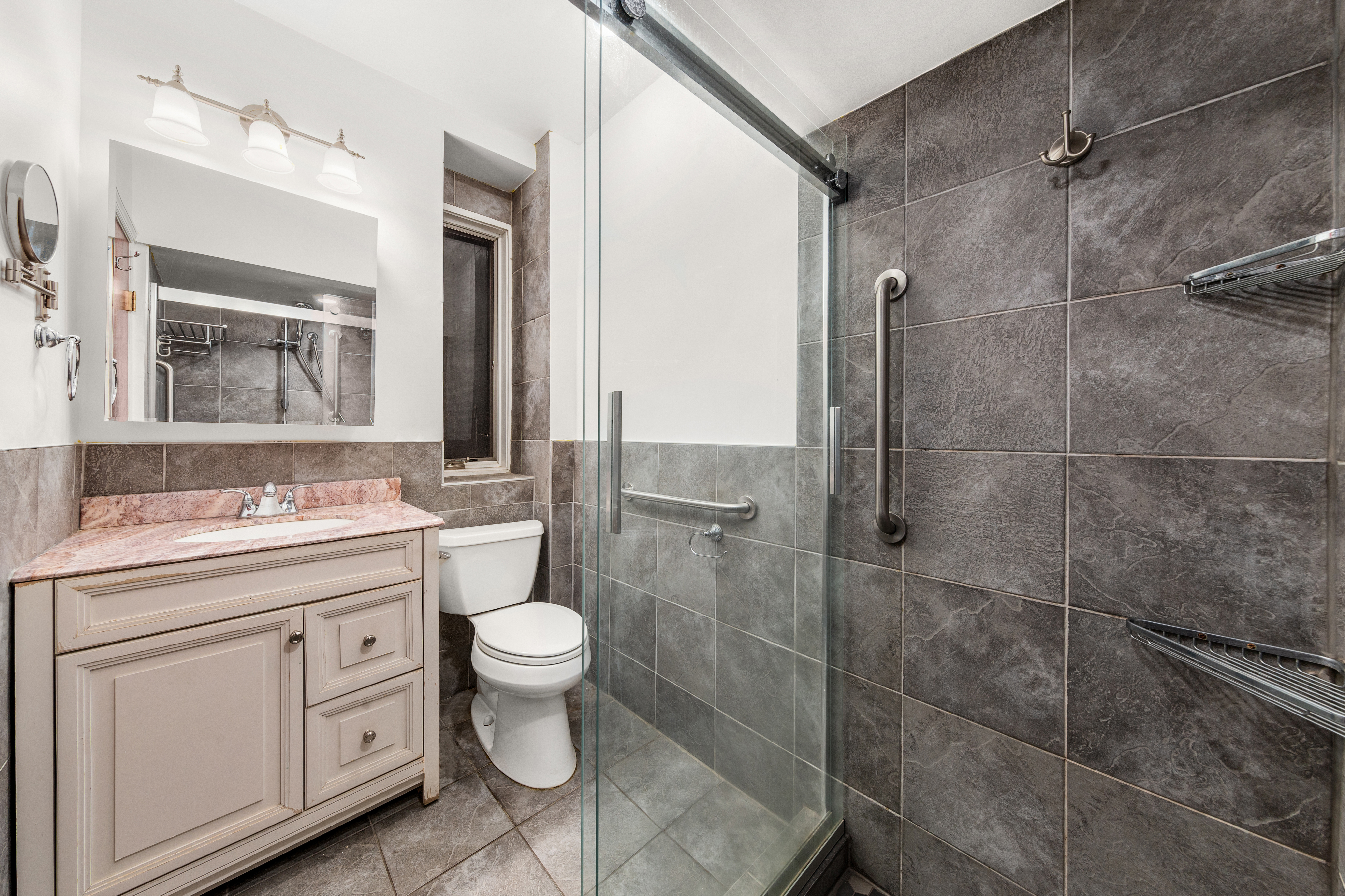 517 East 87th Street, Unit 1 Manhattan, NY 10128 - Photo 9 of 17 a bathroom with a double vanity sink toilet and a mirror