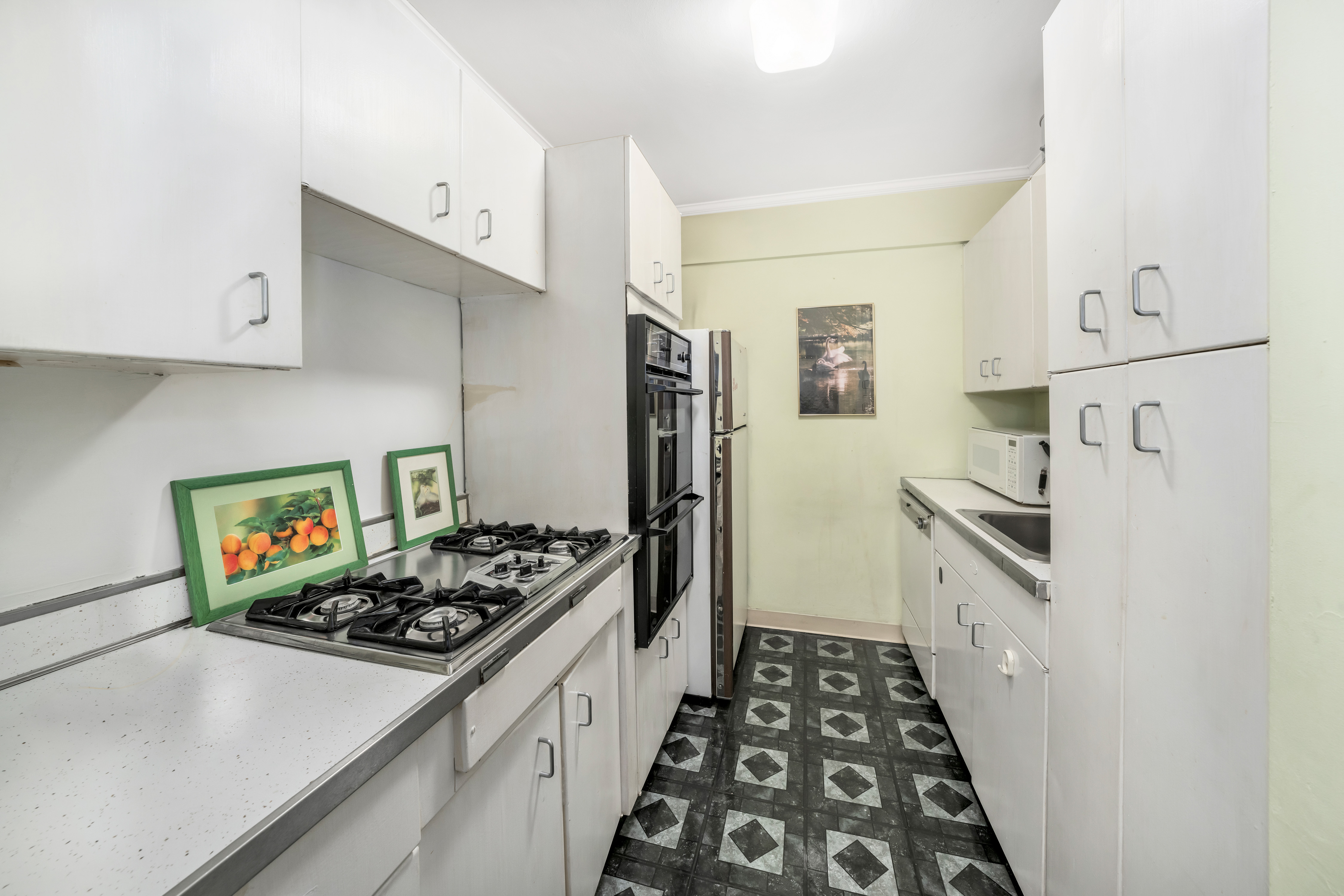 345 East 56th Street, Unit 5C Manhattan, NY 10022 - Photo 4 of 10 a kitchen with stainless steel appliances a stove a sink and a refrigerator