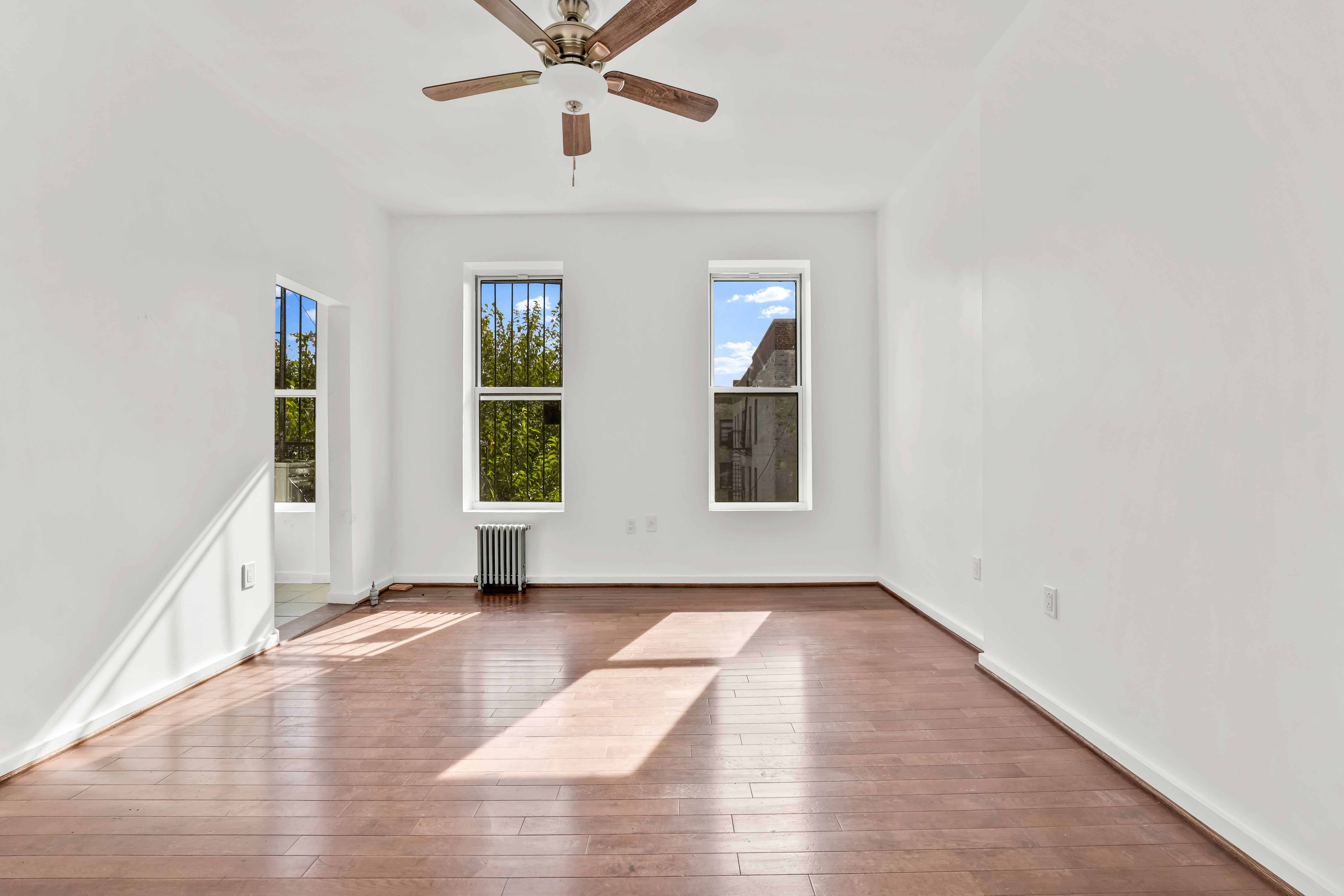 238 Vernon Avenue, Unit 3 Brooklyn, NY 11206 - Photo 8 of 19 a view of an empty room with window and wooden floor