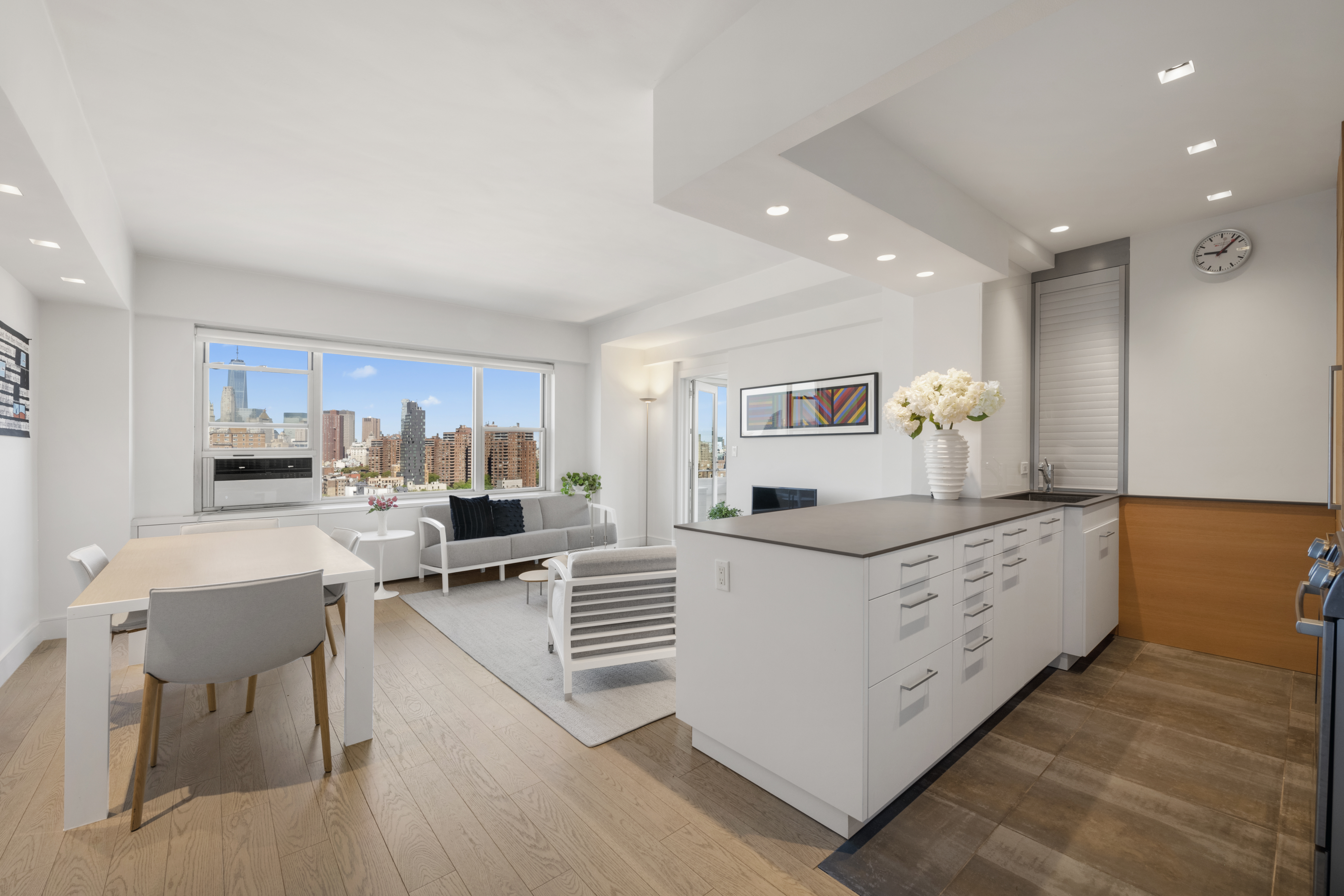 573 Grand Street, Unit D1707/1801 Manhattan, NY 10002 - Photo 6 of 24 a kitchen with stainless steel appliances granite countertop a stove top oven a sink dishwasher and white cabinets with wooden floor