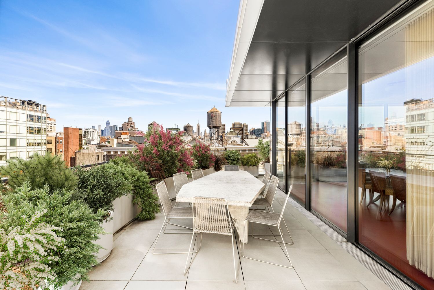 a view of a terrace with furniture and floor to ceiling window