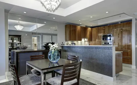 a kitchen with kitchen island granite countertop a table and chairs in it
