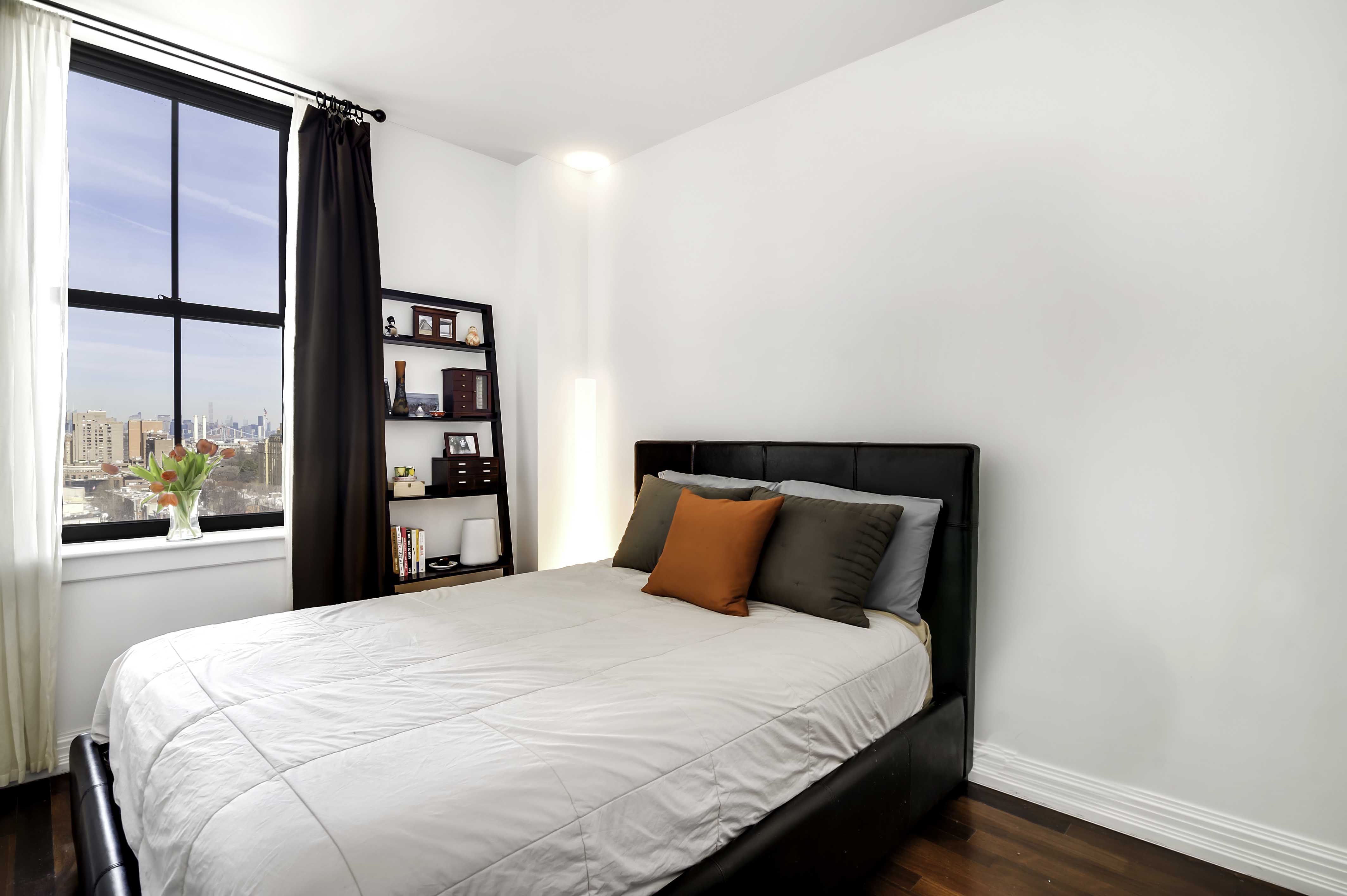 1 Hanson Place, Unit 12F Brooklyn, NY 11243 - Photo 4 of 5 a bedroom with a large bed and a window