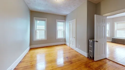 a view of empty room with wooden floor