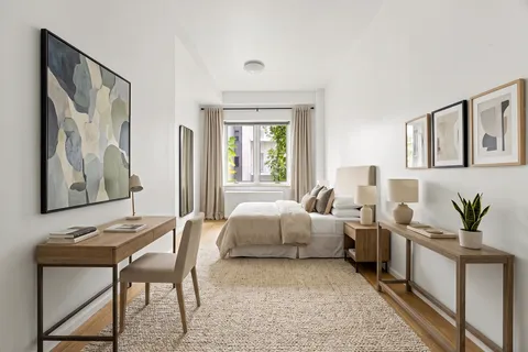 a living room with furniture and paintings on the wall